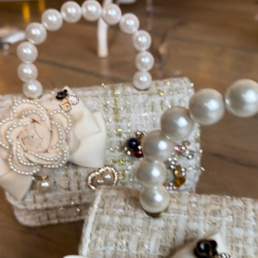 Gaišas krāsas rokassomiņa ar pērlīšu rokturi