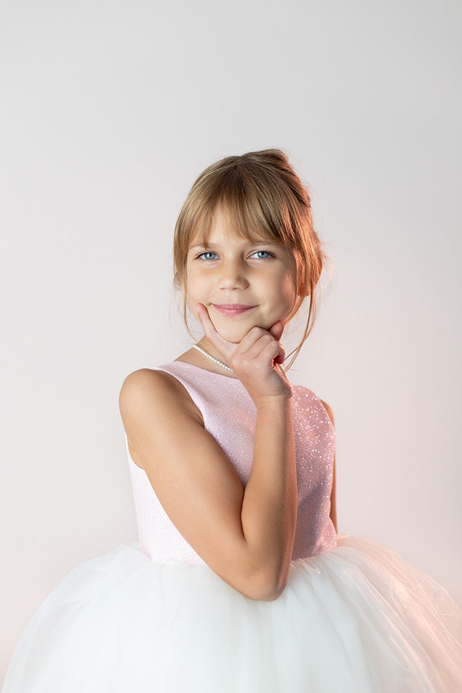 mazā dāma svētku kleitā ar baltiem tilla svārkiem un rozā augšdaļu